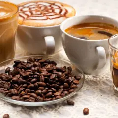 Kawa z mlekiem, espresso i ziarna kawy. Czy kawa z mlekiem tuczy? Zależy od ilości mleka i cukru.